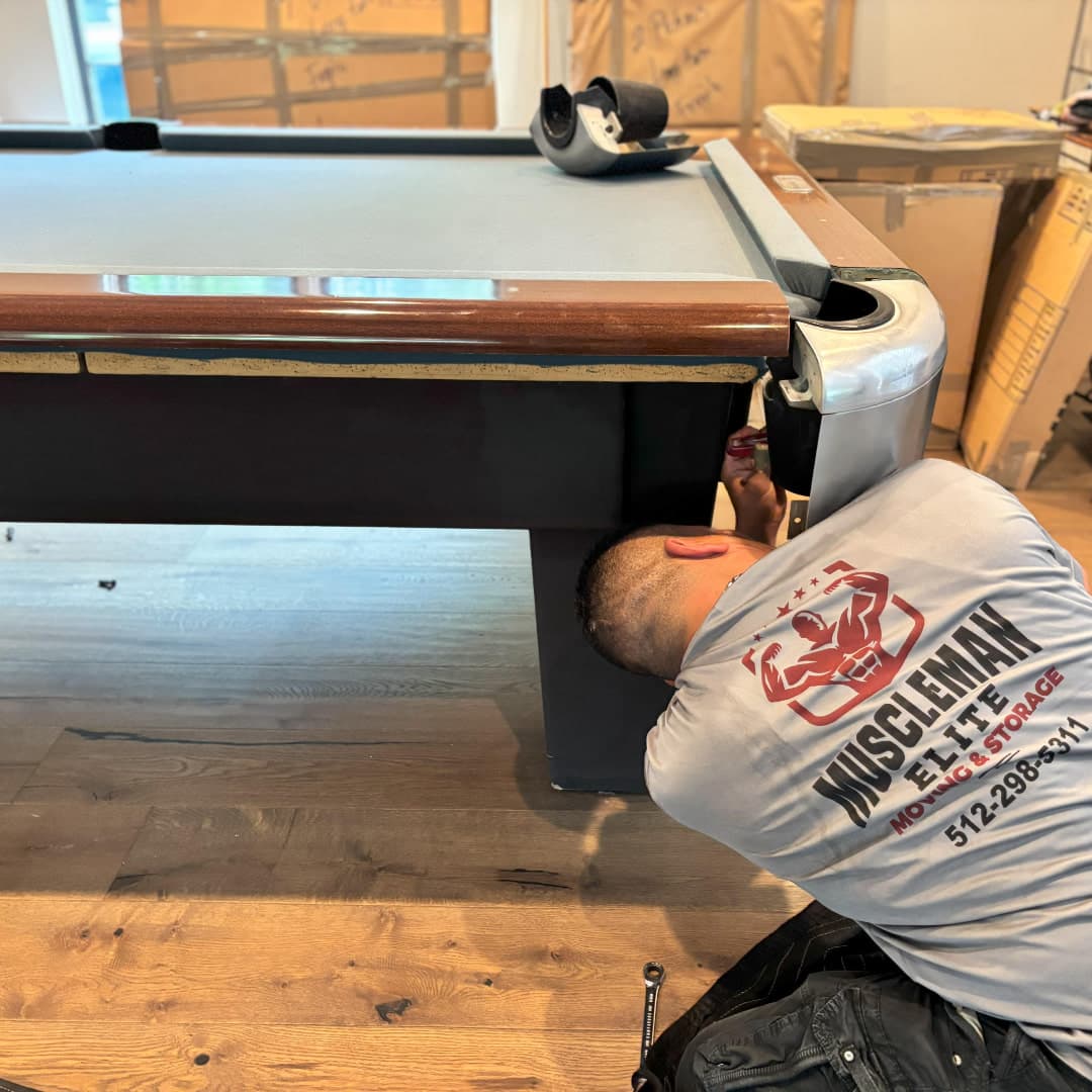 Pool table being disassembled for professional relocation