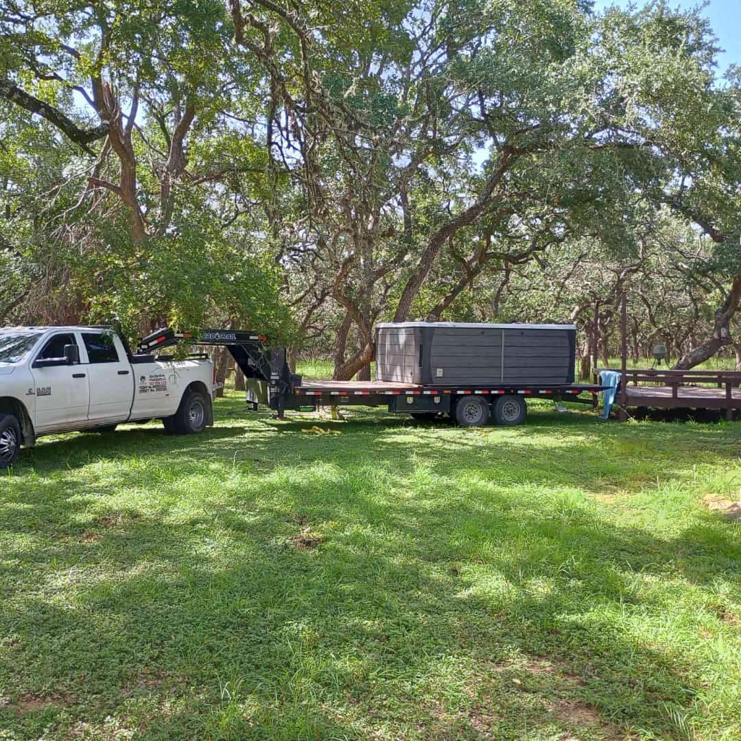 Hot tub being moved through backyard with crane assistance
