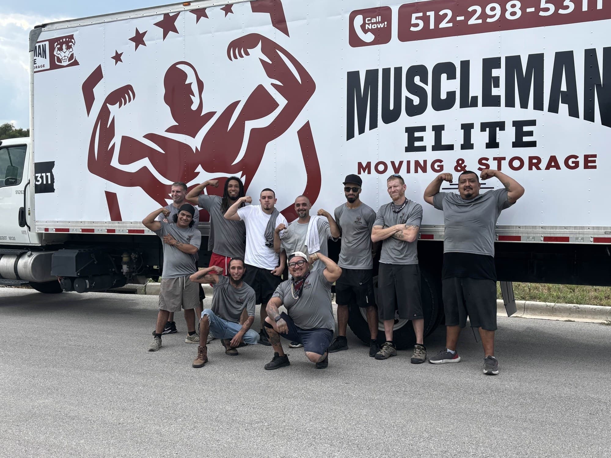 Muscleman Elite crew staged next to moving trucks on an Austin job site