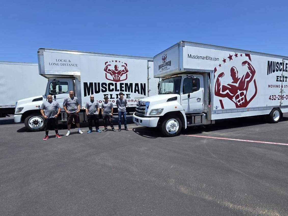 Muscleman Elite Midland crew standing in front of two branded moving trucks
