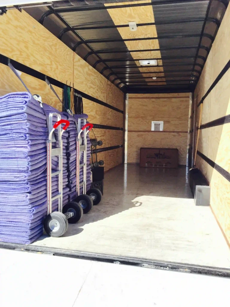 Interior of portable storage container with moving dollies and protective mats.